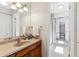 Bright bathroom with a granite-look countertop, a vanity mirror and a glass enclosed shower at 1395 Abilene Dr, Broomfield, CO 80020