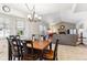 Bright dining area features a chandelier, tan tile flooring, and is adjacent to the home's living room at 1395 Abilene Dr, Broomfield, CO 80020