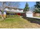 Charming two-story home with a well-manicured lawn, brick accents and a bright red front door at 1395 Abilene Dr, Broomfield, CO 80020