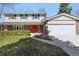 Inviting two-story home with brick facade, a striking red door, and a two-car attached garage at 1395 Abilene Dr, Broomfield, CO 80020