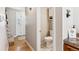 Hallway with wood floors leads to the front door and the downstairs water closet with ceramic tile floor at 1395 Abilene Dr, Broomfield, CO 80020