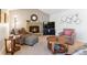 Comfortable living room features a red brick fireplace, neutral carpet, and comfortable seating at 1395 Abilene Dr, Broomfield, CO 80020