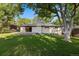 Backyard features lush green lawn, a spacious deck, and mature trees, perfect for outdoor enjoyment at 7036 S Apache St, Littleton, CO 80120