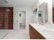 Modern bathroom featuring double vanity, decorative tile shower and marble floors at 7036 S Apache St, Littleton, CO 80120