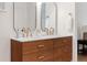 Modern bathroom with dual vanity, wood cabinets, gold fixtures and hardware at 7036 S Apache St, Littleton, CO 80120