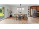 Bright dining room features wood floors, modern lighting, and a view to the backyard at 7036 S Apache St, Littleton, CO 80120