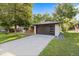 A modern garage with a sleek dark door, set against a well-maintained lawn and blue sky backdrop at 7036 S Apache St, Littleton, CO 80120