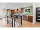 Open-concept kitchen featuring wooden cabinetry, stainless steel appliances, and access to a lower level at 7036 S Apache St, Littleton, CO 80120