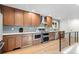 Spacious kitchen features wooden cabinetry, modern stainless steel appliances, and stylish backsplash at 7036 S Apache St, Littleton, CO 80120