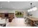 Open-concept living room with stone fireplace, wood floors, and sliding glass doors to the backyard at 7036 S Apache St, Littleton, CO 80120