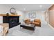 Basement living room features fireplace, tan leather couch, and warm decor creating an inviting gathering space at 7036 S Apache St, Littleton, CO 80120