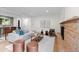 Open-concept living room with stone fireplace, modern decor, and seamless flow to kitchen at 7036 S Apache St, Littleton, CO 80120