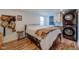 Charming bedroom features hardwood floors, a stacked washer and dryer, and eclectic decor at 329 2Nd St, Frederick, CO 80530