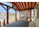 Comfortable covered porch with a wood ceiling and posts and seating facing the street at 329 2Nd St, Frederick, CO 80530