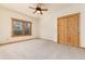 Bedroom with carpet, natural wood trim, large window, and ceiling fan at 1970 Garland St, Lakewood, CO 80215