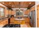 A view of the kitchen with wood cabinets, granite countertops, stainless steel appliances, and hardwood flooring at 1970 Garland St, Lakewood, CO 80215