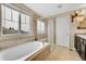 Bathroom featuring a large tub, glass shower, and vanity offering a relaxing space at 239 N Irvington St, Aurora, CO 80018