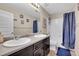 Bathroom with double vanity, framed mirrors, and a shower-tub combination with blue shower curtain at 239 N Irvington St, Aurora, CO 80018