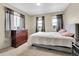 Bedroom featuring two windows dressed in dark grey, a dark dresser, and a gray queen bed at 239 N Irvington St, Aurora, CO 80018