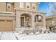 Charming home exterior featuring brick accents, covered front porch, and snow-covered yard at 239 N Irvington St, Aurora, CO 80018