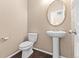 Powder room with pedestal sink, oval mirror and hardwood floors at 21893 E Layton Dr, Aurora, CO 80015