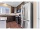 Modern kitchen features stainless steel appliances, dark wood cabinets, granite counters, and wood flooring at 21893 E Layton Dr, Aurora, CO 80015