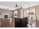 Granite kitchen island featuring dark cabinetry, stainless lighting, and an open-concept design to the living and dining areas at 21893 E Layton Dr, Aurora, CO 80015