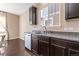 Kitchen sink with dark cabinetry, stainless steel appliances, and a window providing natural light to the space at 21893 E Layton Dr, Aurora, CO 80015