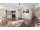 Sun-drenched open layout with hardwood floors leading from a modern kitchen to a cozy living space with a mounted TV at 21893 E Layton Dr, Aurora, CO 80015