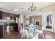 Open-concept kitchen, dining, and living space with a fireplace, island, and hardwood floors at 21893 E Layton Dr, Aurora, CO 80015
