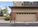Attached two car garage with tan door and brick facade, with additional exterior utility hookups at 188 S Locust St, Denver, CO 80224