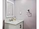 Stylish half bathroom featuring a white vanity with marble countertop and bronze fixtures at 7192 S Vine E Cir, Centennial, CO 80122