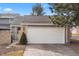 Attached two car garage of lovely home featuring brick accents, mature landscaping, and a well-maintained driveway at 7192 S Vine E Cir, Centennial, CO 80122