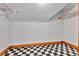 Unfinished basement space with classic black and white checkerboard flooring at 7011 Grandview Ave, Arvada, CO 80002