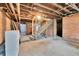 Unfinished basement with exposed brick walls and concrete floor, ready for customization at 7011 Grandview Ave, Arvada, CO 80002