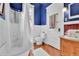 Charming bathroom features blue walls, wood floors, and a classic clawfoot tub with shower at 7011 Grandview Ave, Arvada, CO 80002