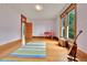 Bright bedroom with hardwood floors, large windows, and colorful accent rug at 7011 Grandview Ave, Arvada, CO 80002