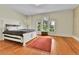 Bright bedroom with hardwood floors, large windows, and a comfortable white-framed bed at 7011 Grandview Ave, Arvada, CO 80002