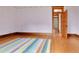 Light-filled bedroom with hardwood floors, colorful rug, and access to another room at 7011 Grandview Ave, Arvada, CO 80002