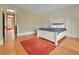 Sunlit bedroom featuring hardwood floors, a large bed, and a colorful rug at 7011 Grandview Ave, Arvada, CO 80002