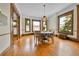 Light-filled dining room boasting wood floors, large windows, and vintage lighting at 7011 Grandview Ave, Arvada, CO 80002