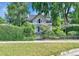 Charming home is surrounded by mature landscaping, a low fence, and a green hedge at 7011 Grandview Ave, Arvada, CO 80002