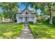 Charming two-story home boasts a welcoming front porch and well-manicured lawn with mature trees at 7011 Grandview Ave, Arvada, CO 80002
