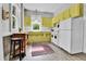 Cozy kitchen features unique yellow cabinetry, a vintage rug, and abundant natural light at 7011 Grandview Ave, Arvada, CO 80002