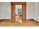 Living room featuring pocket doors, hardwood floors, and view into a charming dining space at 7011 Grandview Ave, Arvada, CO 80002