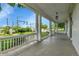 A covered porch with white pillars, offering an outdoor seating area with a view of the street at 7011 Grandview Ave, Arvada, CO 80002