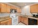Bright kitchen featuring oak cabinets, granite countertops, and white appliances at 11141 Gaylord St, Northglenn, CO 80233