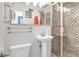 This bathroom features a mosaic tiled shower, pedestal sink, and modern fixtures at 1935 Oneida St, Denver, CO 80220
