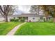 Charming single-story home with lush green lawn, walkway, and manicured landscaping at 1935 Oneida St, Denver, CO 80220