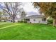 Charming home with a well-manicured lawn, vibrant greenery, and an inviting curb appeal at 1935 Oneida St, Denver, CO 80220
